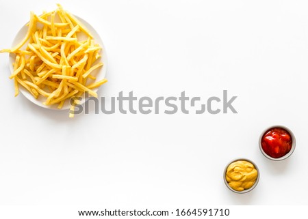 Fast food symbol. French fries on plate on white table top-down copy space