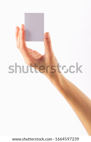 asian female hand holds white empty paper card on a white background.