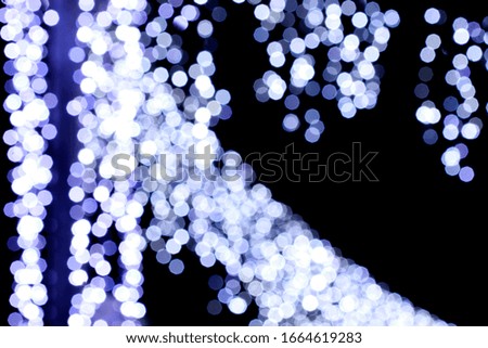 Blurred abstract background with blue and silver glittering christmas lights.