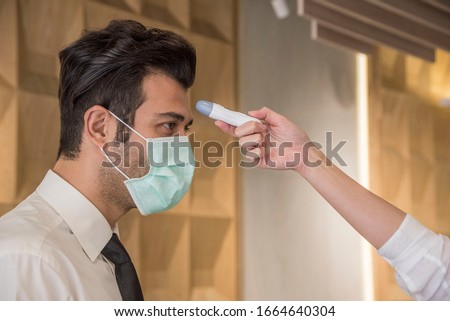 Visitors must go through fever measures using infrared  digital thermometer check temperature measurement, fever examination
at the building.Measures to prevent people with fever, Covid 19 concept Royalty-Free Stock Photo #1664640304