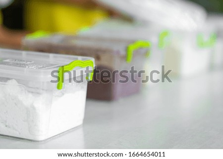 Kitchen, plastic transparent box with flour. Ingredients for cooking.