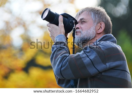 Elderly man taking photos in nature