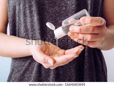 Close up view of woman person using small portable antibacterial hand sanitizer on hands. Royalty-Free Stock Photo #1664685844
