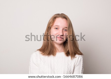 Cheerful teen girl. Studio image of a cute smiling young girl on a gray background.