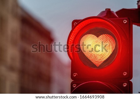 A city crossing with a semaphore,  traffic light with red heart-shape in semaphore - image