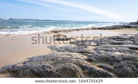 rocks at the beach with wave and beautiful blue sky background