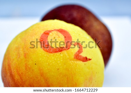 text O2 handwritten on a yellow apple with waterdrops