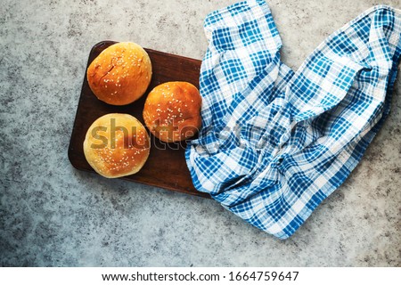 homemade burger buns with sesame on wooden board