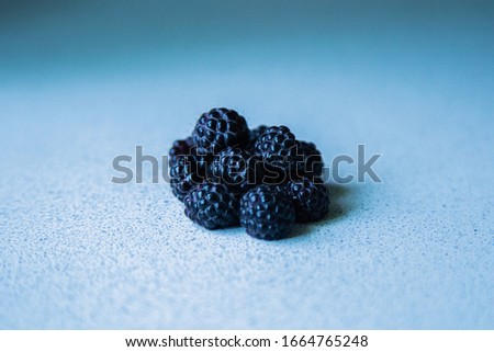 BlackBerry berries stacked in a pyramid on a light background