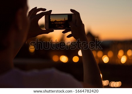 Girl photographs the night lights of Florence. Tourism concept. Mixed media