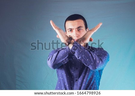 men shows arms crossed gesture on a gray background