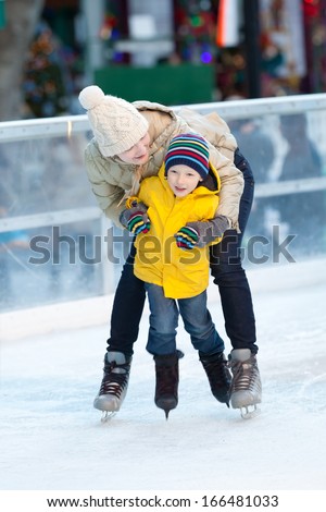 happy positive family of two ice skating at winter