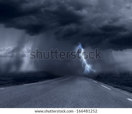 Dark stormy clouds over road