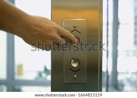 Detail view of hand pushing elevator button