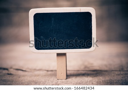 Small wooden framed blackboard on wooden background 