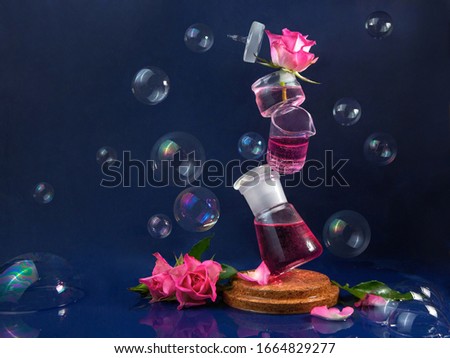 Several flasks are in the air. Levitation. Pink roses and soap bubbles. Blue background. Magic, mystical picture.