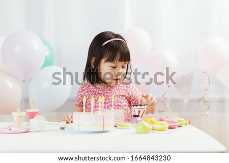 toddler girl pretend play food preparing role at home against white background