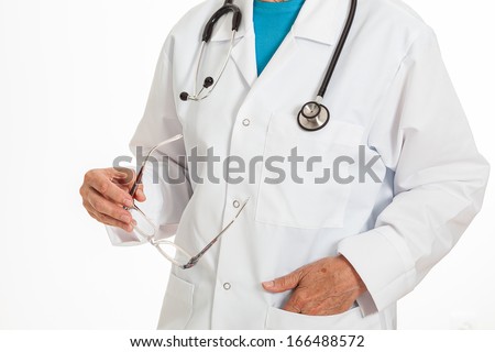 A smart doctor standing straight holding his glasses