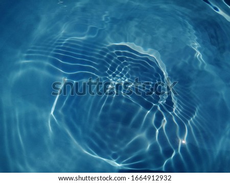 The​ pattern​ of​ surface​ blue​ water​ in​ the​ deep​ sea​ for​ blue​ background. Abstract​ of​ surface​ blue​ water​ in​ the​ swimming​ pool​ for​ background. Water​ splashed​ for​ background​