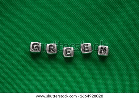 Word green made of cubes on a green background. Color texture.Defocus