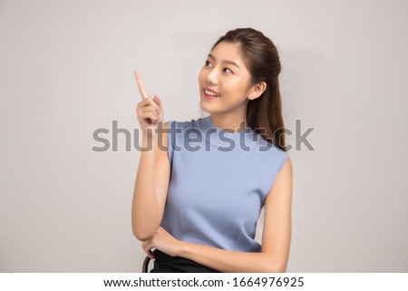Thinking asian woman stand up  isolated on white background.Asian female model smiling looking up.woman pointing fingers away on white background  isolated.