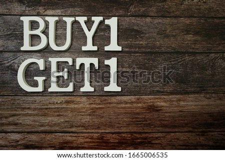 Buy 1 Get 1 with space copy on wooden background