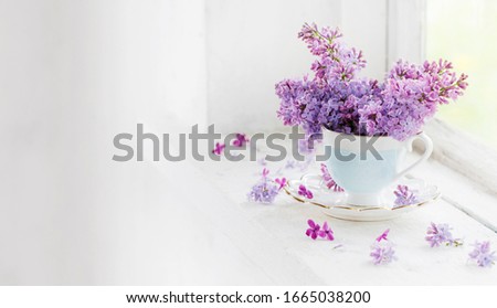 bouquet of lilacs in ceramic cup  on old white windowsill