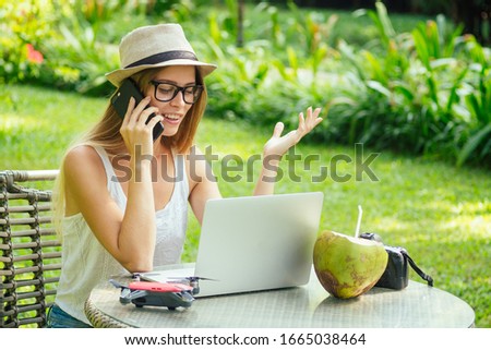 girl at cafe talking by phone with client about photoshoot on vacation on beach
