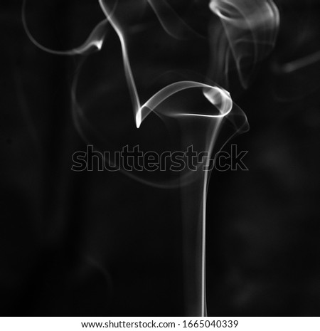 Incense smoke shot against a black background