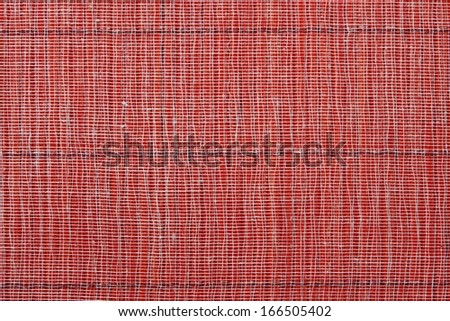 Texture of a red straw mat with a basis from a gauze for an abstract background