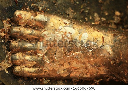 close up of left foot of the golden Buddha statue.  gold leaves placed on Buddha's feet. 