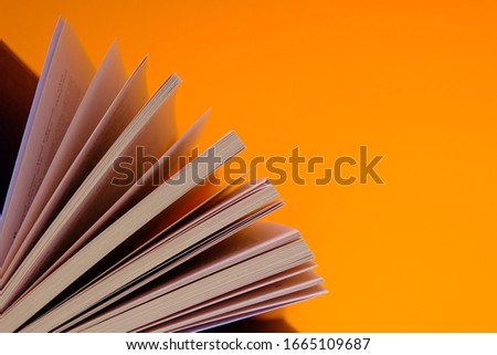  Books with spread out pages on a orange background. Book Day.Book pages close-up. Reading and education concept. Knowledge