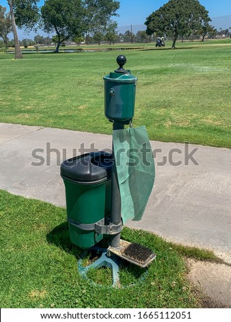 Golf ball  and club washer with golf shoe brush cleaner at a golf course.
