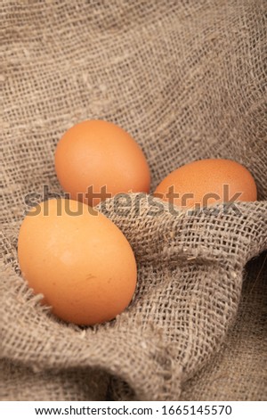 Chicken eggs on a background of rough homespun fabric. Country food. Close up.