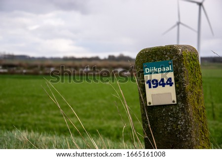 Dyke pile sign in front of landscape