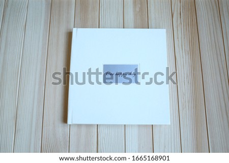 album photo book in a leatherette leather cover on a wooden background with a bouquet of lavender