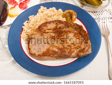 Image of tasty pearl barley with fried beef at plate on table, nobody