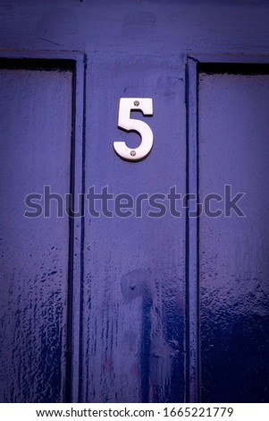 House number 5 on a blue wooden front door