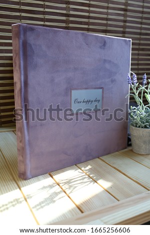 album photo book with a metal insert and an inscription in a villa cover with a decor next to the flowers in a small pot