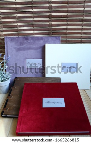 
album photo book with a metal insert and an inscription in a red villa cover with a decor next to flowers