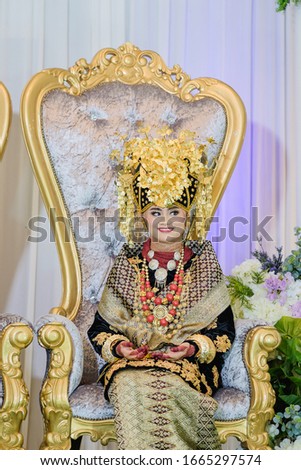 A beautiful bride wearing traditional Minang wedding dress with accessories for traditional wedding bride.