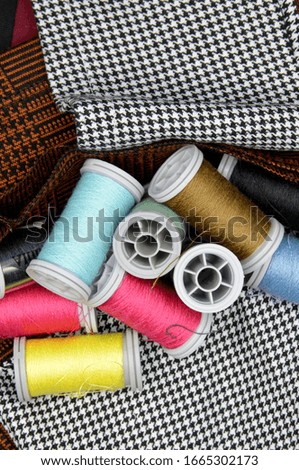 colorful spools of thread on fabric background