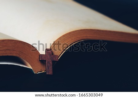 Close up cross and open bible book on black background, vintage tone
