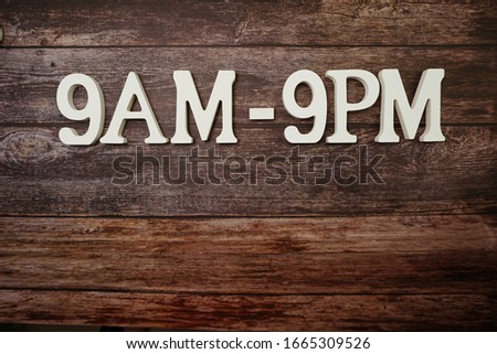 Opening Times 9 am to 9pm letter on wooden background