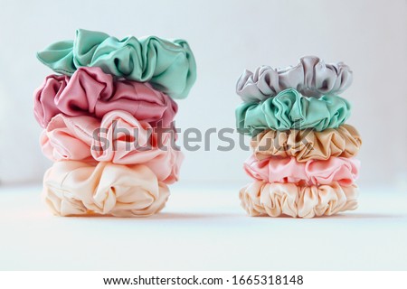 Lot of Colorful silk Scrunchies on white. Luxury Hairdressing tools and accessories. Hair Scrunchies, Elastic HairBands, Bobble Sports Scrunchie Hairband Royalty-Free Stock Photo #1665318148