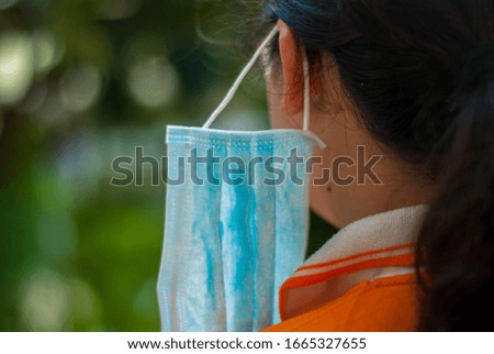 Three layers of blue mask to protect against dust and corona virus through the user's shoulder