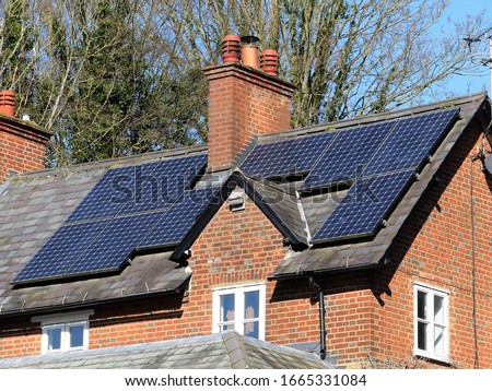 Solar panels on house rooftop used to generate electricity Royalty-Free Stock Photo #1665331084