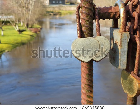 Dual heart-shaped love lock hanging on a bridge. Valentines day background. Marriage background. Sunny bright day.
