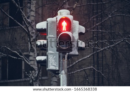 Snow-covered red traffic light for pedestrians, Finland.