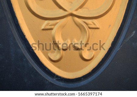 golden round decorative elements with a symbol of the sun and a flower on the front black door, home interior